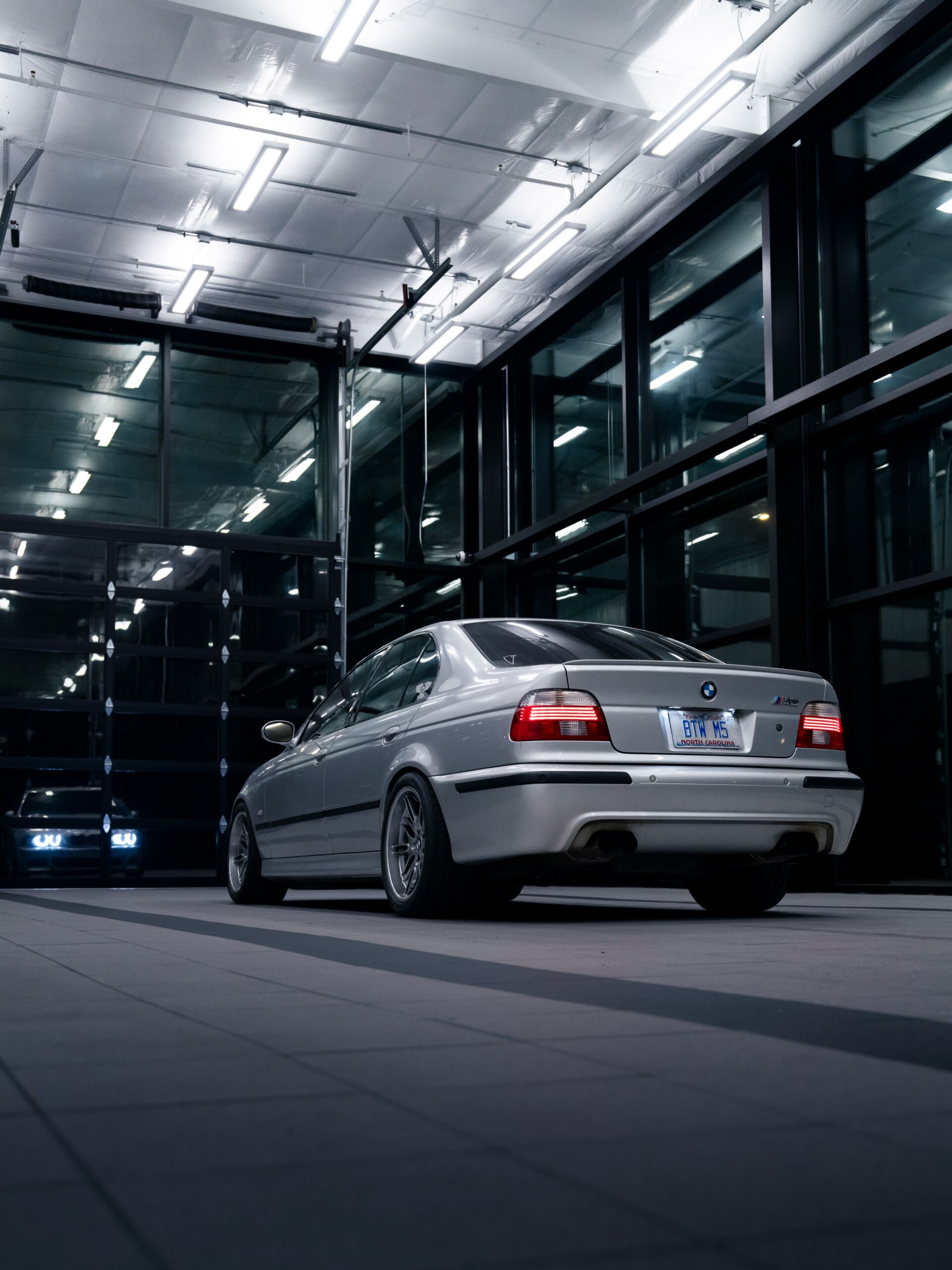 Rear three-quarter view of the silver E39 BMW M5 inside Bimmer Performance Center
