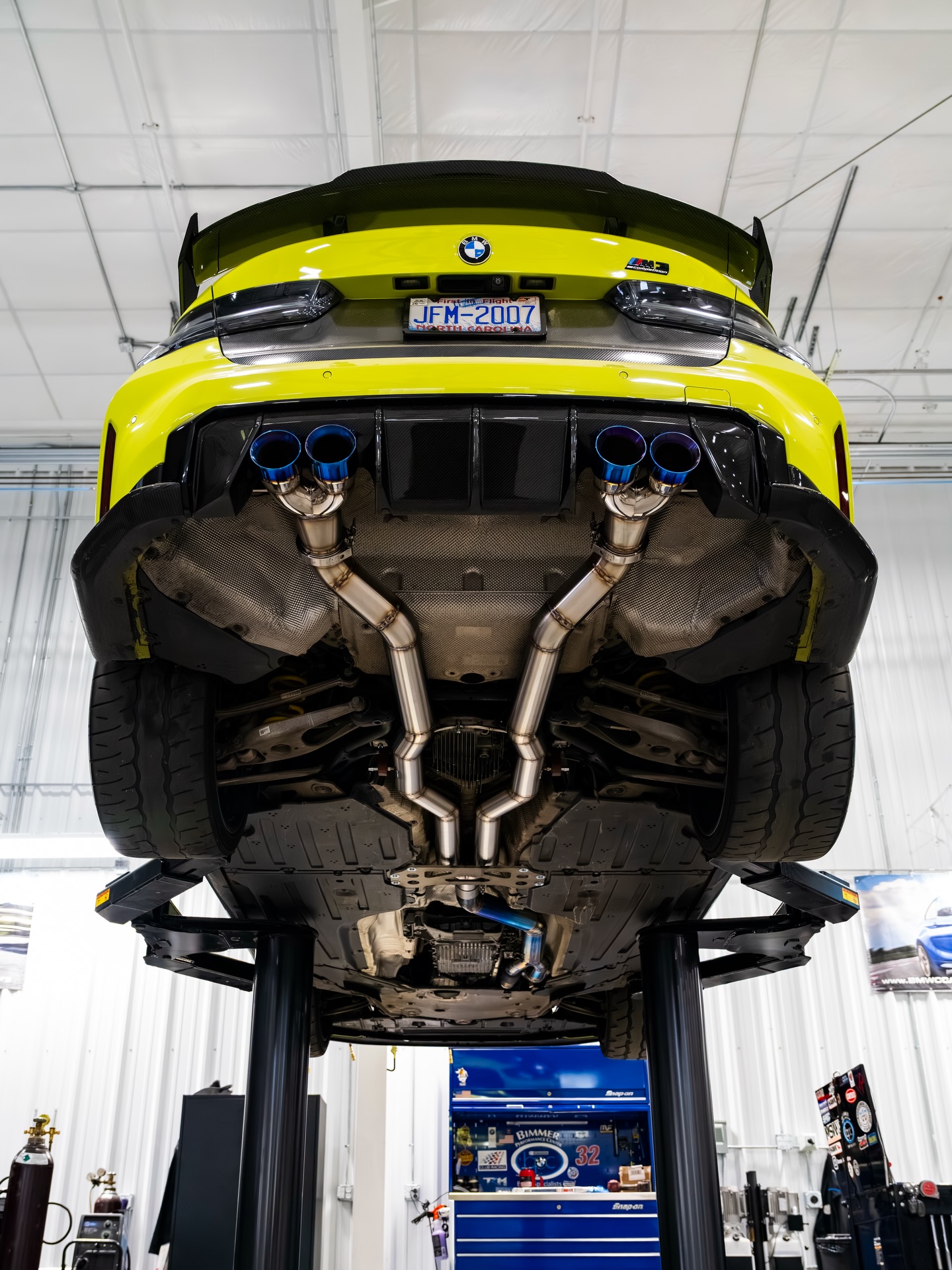 BMW M3 on a lift with its BPC custom exhaust visible beneath the car